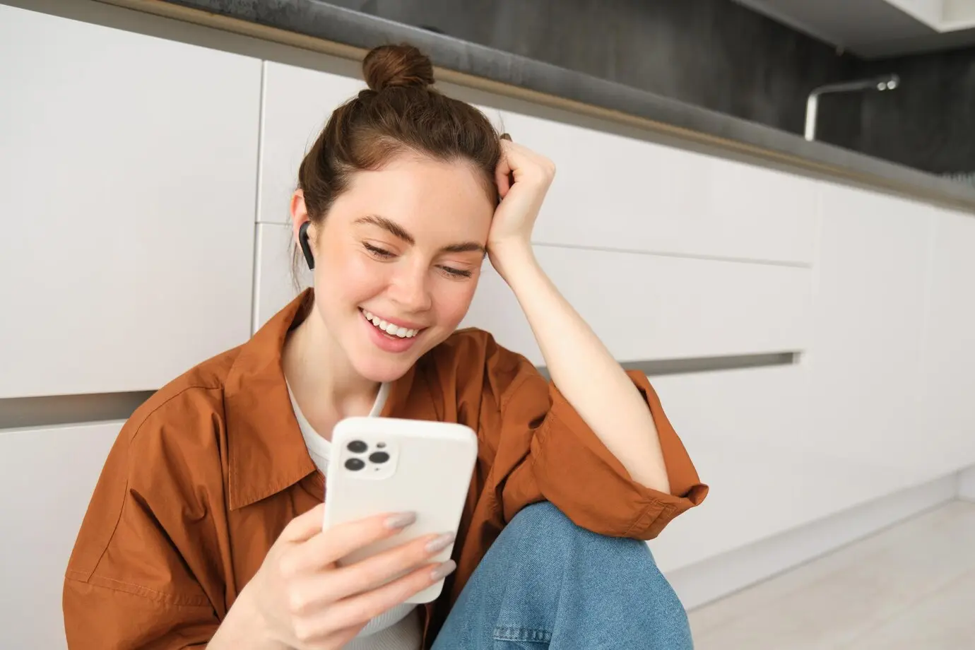 A woman smiling while looking at her phone