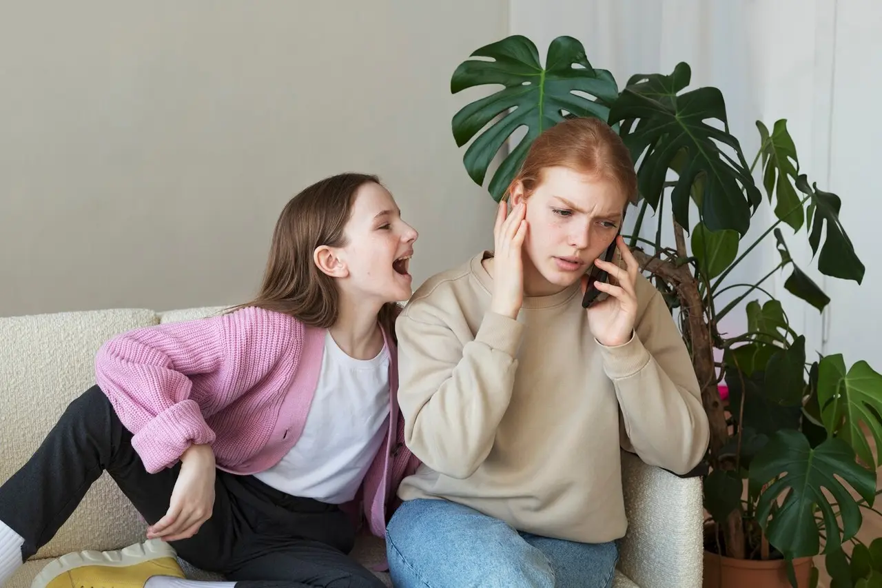 Girl screaming next to woman on phone