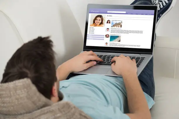 The man lying on sofa viewing a beautiful girl's profile