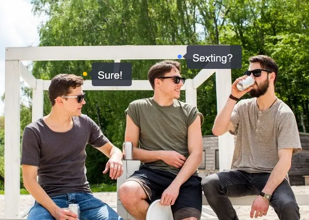 Three men sit in the park and chat