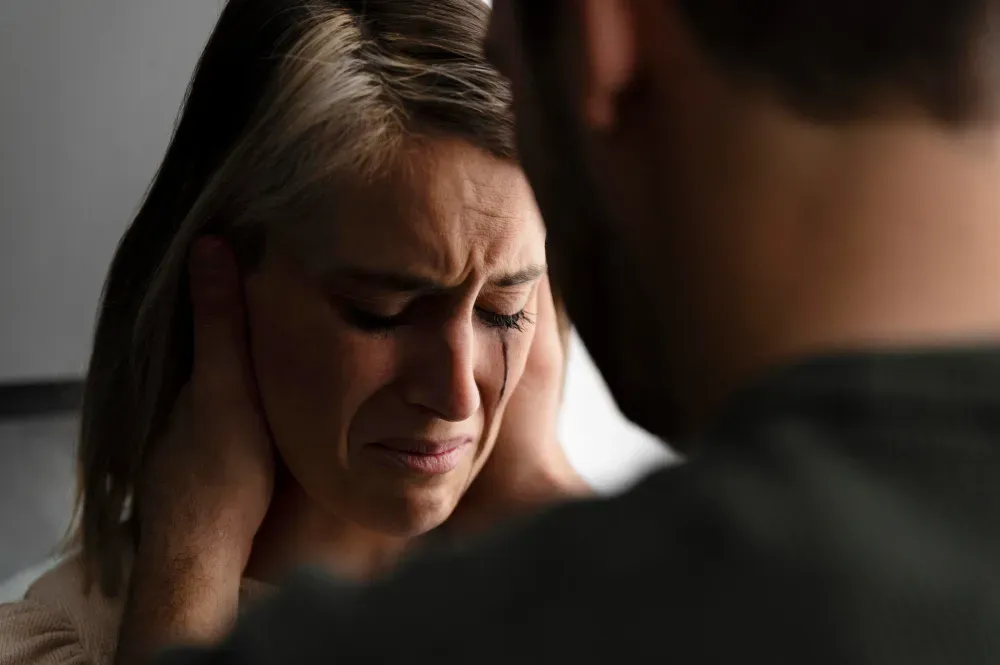 A cheater holding his crying wife head