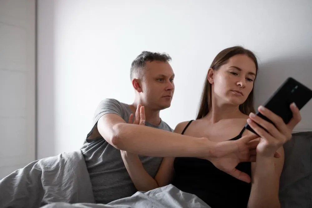 Upset husband hindering his wife from using his phone